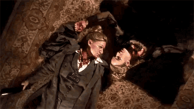 a man and a woman are laying on the floor . the woman has a name tag that says j.