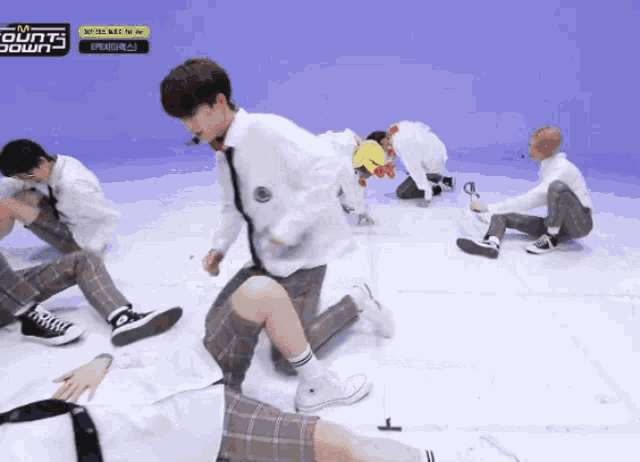 a group of young men are dancing on a stage with a sign that says m count down