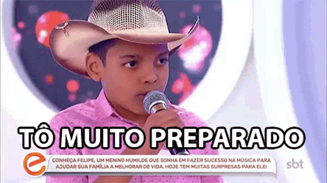a young boy wearing a cowboy hat is singing into a microphone with the words to muito preparado above him