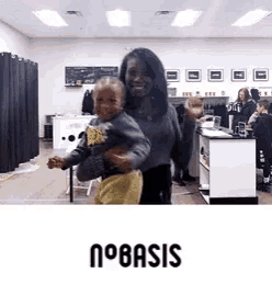 a woman is holding a baby in her arms and the word basis is on the bottom