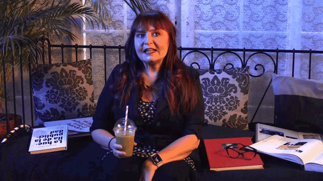 a woman sits on a couch holding a drink in front of a book that says la rue
