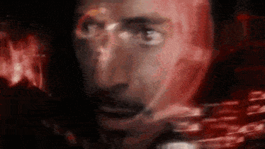 a close up of a man 's face with a red background