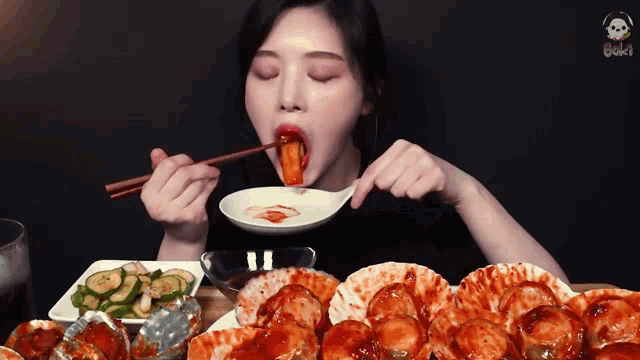 a woman is eating food with chopsticks and a spoon with a skull on it