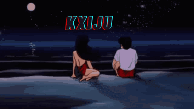 a man and a woman are sitting on a beach under a sign that says kxjju