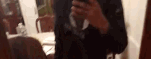 a person is taking a selfie in front of a mirror with a cell phone .