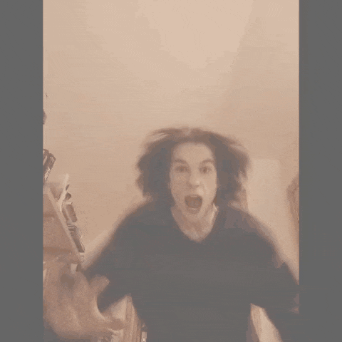a blurry picture of a woman screaming with her mouth open in a room .