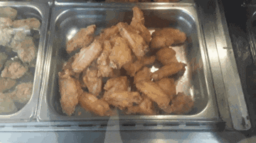 a tray of fried chicken wings sits on a counter
