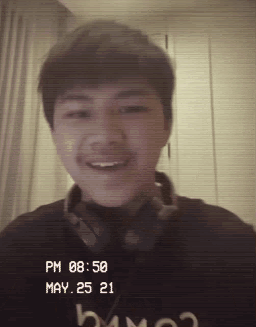 a young man is wearing headphones and a black shirt with the date may 25 21 on it