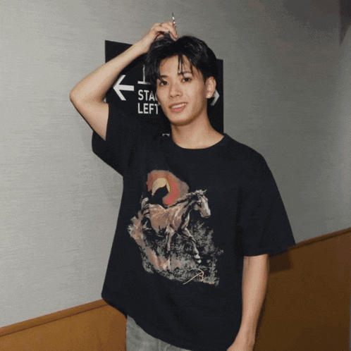 a young man wearing a black t-shirt with a horse on it