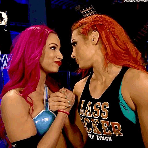 two women with red hair are holding hands and one has a shirt that says lass rocker