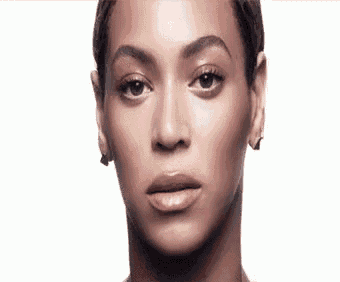 a close up of a woman 's face with a white background and a serious look on her face .