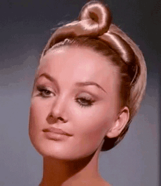 a close up of a woman with a bun in her hair