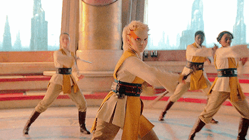 a woman in a yellow and white outfit is holding a sword in her hand