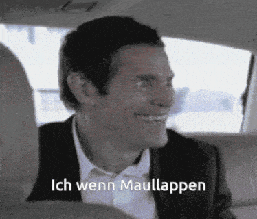 a man in a suit and tie is smiling with the words ich wenn maullappen behind him