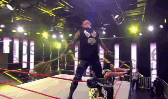 a wrestler is standing in a wrestling ring holding a flag
