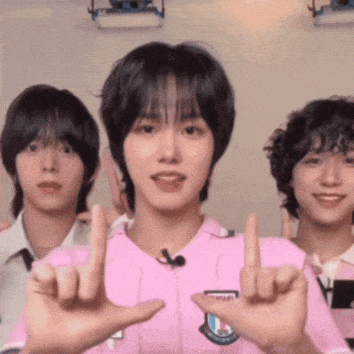 a group of young men are standing next to each other giving the middle finger