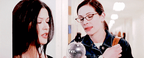 two women are standing next to each other and one of them is holding a bottle that says yes