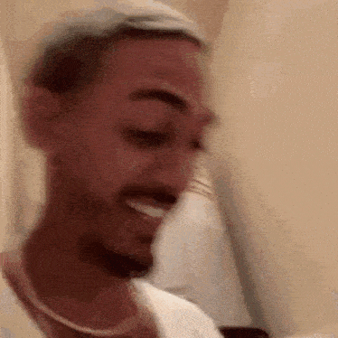 a blurry picture of a man with a beard wearing a white shirt .