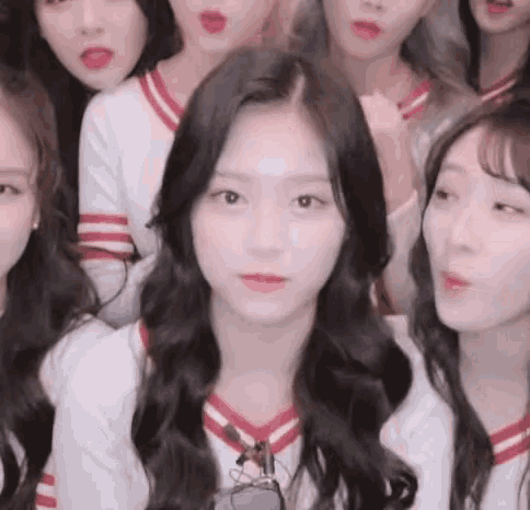 a group of young women are standing next to each other .