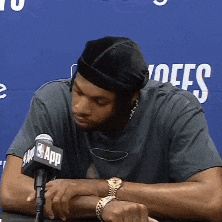 a man sitting in front of a microphone with the nba app logo on it