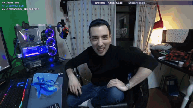 a man sitting in front of a computer with a donation button on the top right