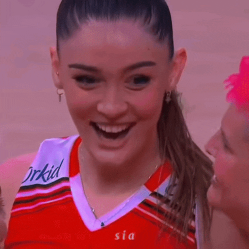 a woman in a red and white jersey with the word orkid on it is smiling