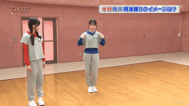 two girls are standing in a room with a sign that says ' tokyo dome '