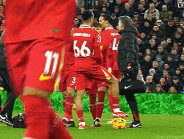 a soccer player with the number 66 on his back is surrounded by other players