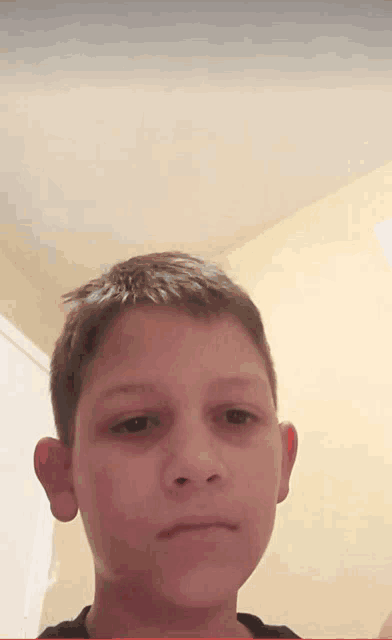 a close up of a boy 's face with a yellow background
