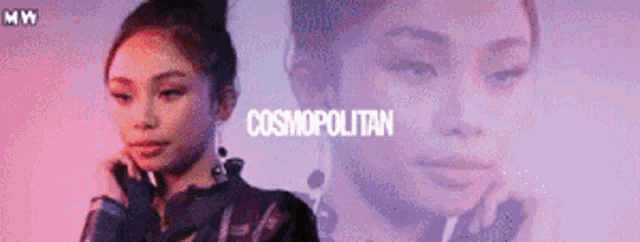 a woman is standing in front of a large screen with the word cosmopolitan on it .