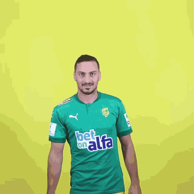 a man wearing a green shirt that says bet on alfa on it