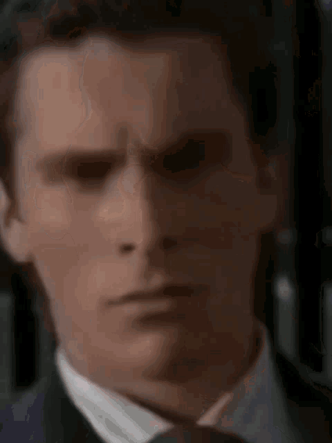 a close up of a man in a suit and tie making a funny face .