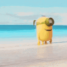a yellow minion with a green headband is standing on a beach