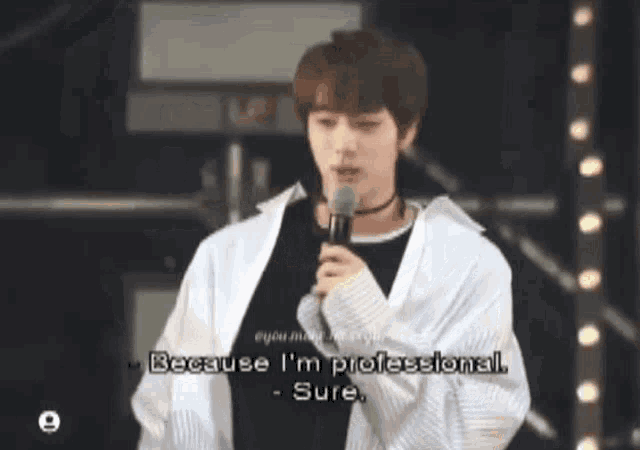 a young man is holding a microphone and saying because i 'm professional - sure