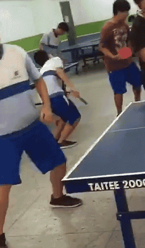 a group of people are playing ping pong on a table that says taitee 2000 on it