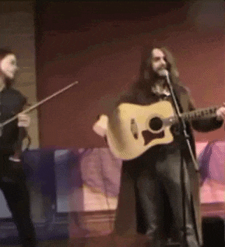 a man is singing into a microphone while playing a guitar