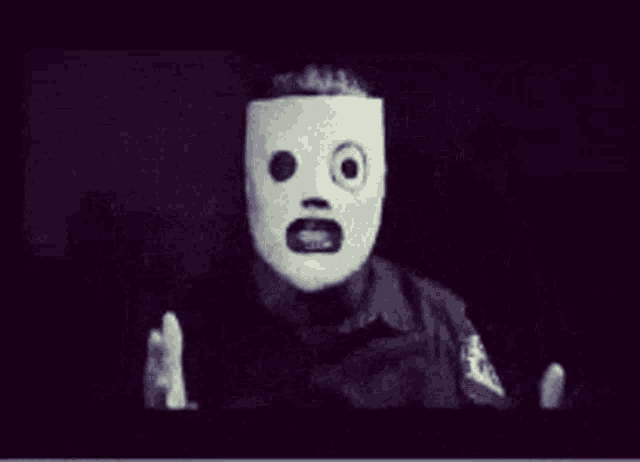 a black and white photo of a person with a white mask on