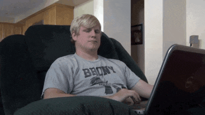 a man wearing a shirt that says bronx sits in a chair