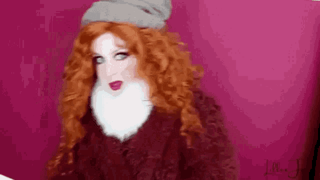 a woman with red hair and a beard is wearing a fur coat and a hat .