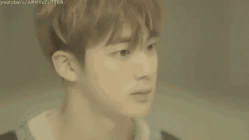 a close up of a young man 's face with a blurry background .