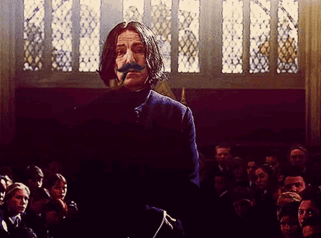 a man with a mustache stands in front of a crowd