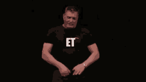 a man in a black shirt is standing in front of a black background with the word defouraille written in white letters .