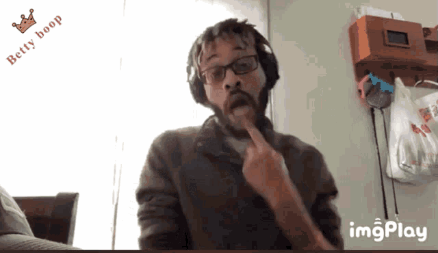a man wearing headphones and glasses has a betty boop logo on the bottom