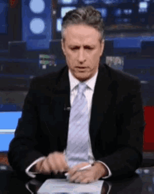 a man in a suit and tie sitting at a desk