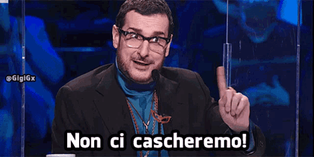 a man wearing glasses and a blue turtleneck says non ci caccheremo