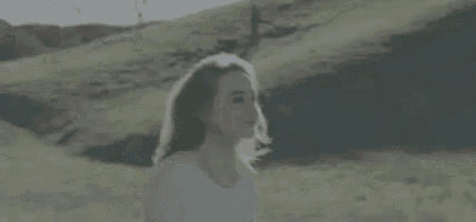 a woman in a white shirt is standing in a field .