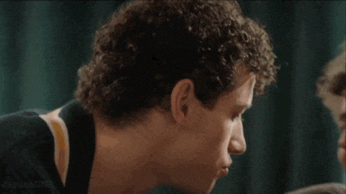 two young men are kissing each other on the forehead and smiling .