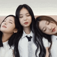 three girls are sitting next to each other with their eyes closed .