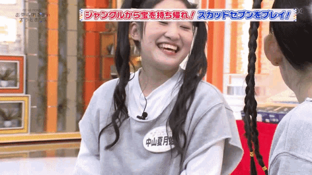 a girl with a name tag that says ' aoyama ' on it smiles