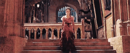 a woman in a red dress is walking up a set of stairs .